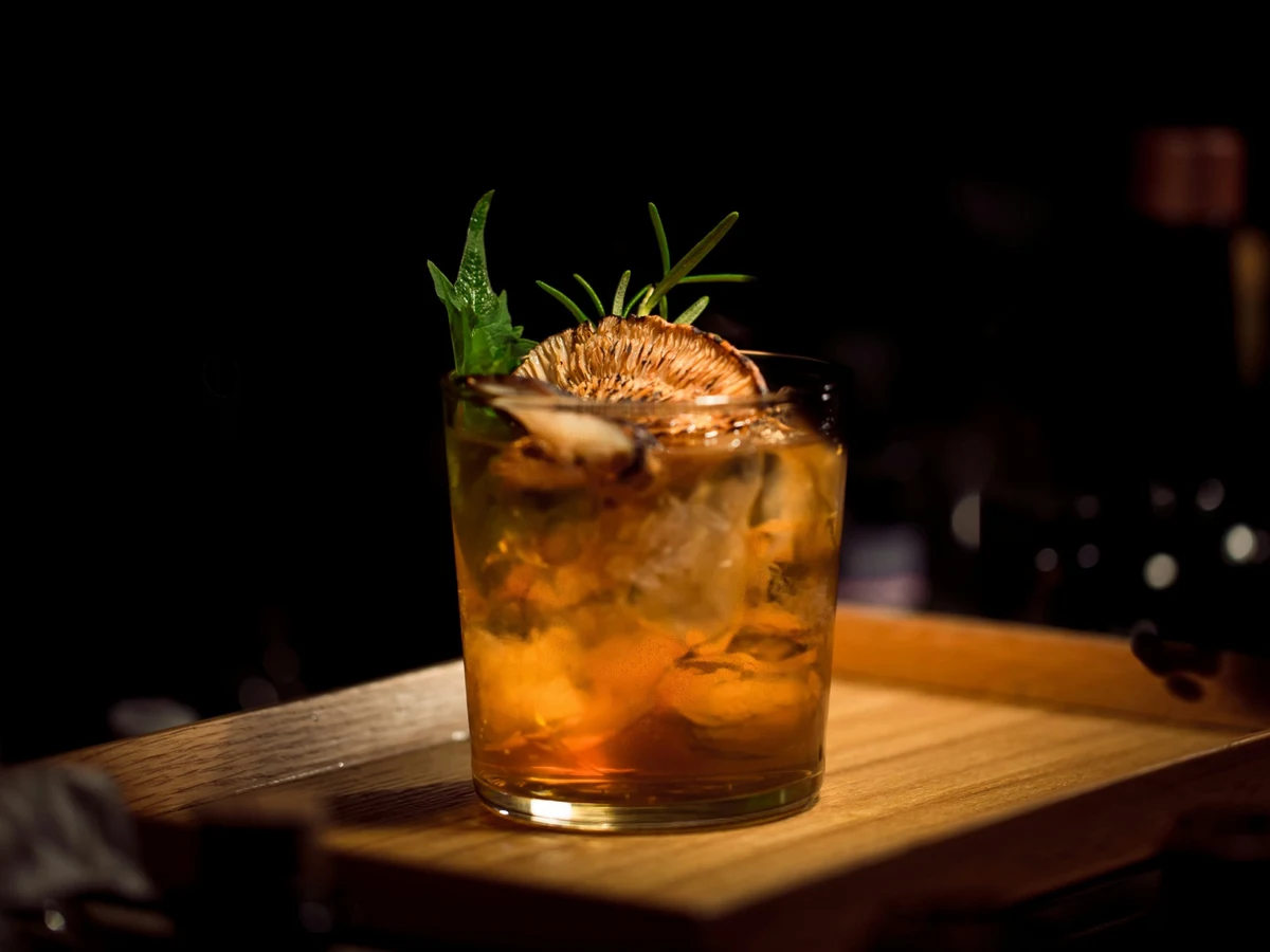 Bartender che prepara cocktail in un bar affollato